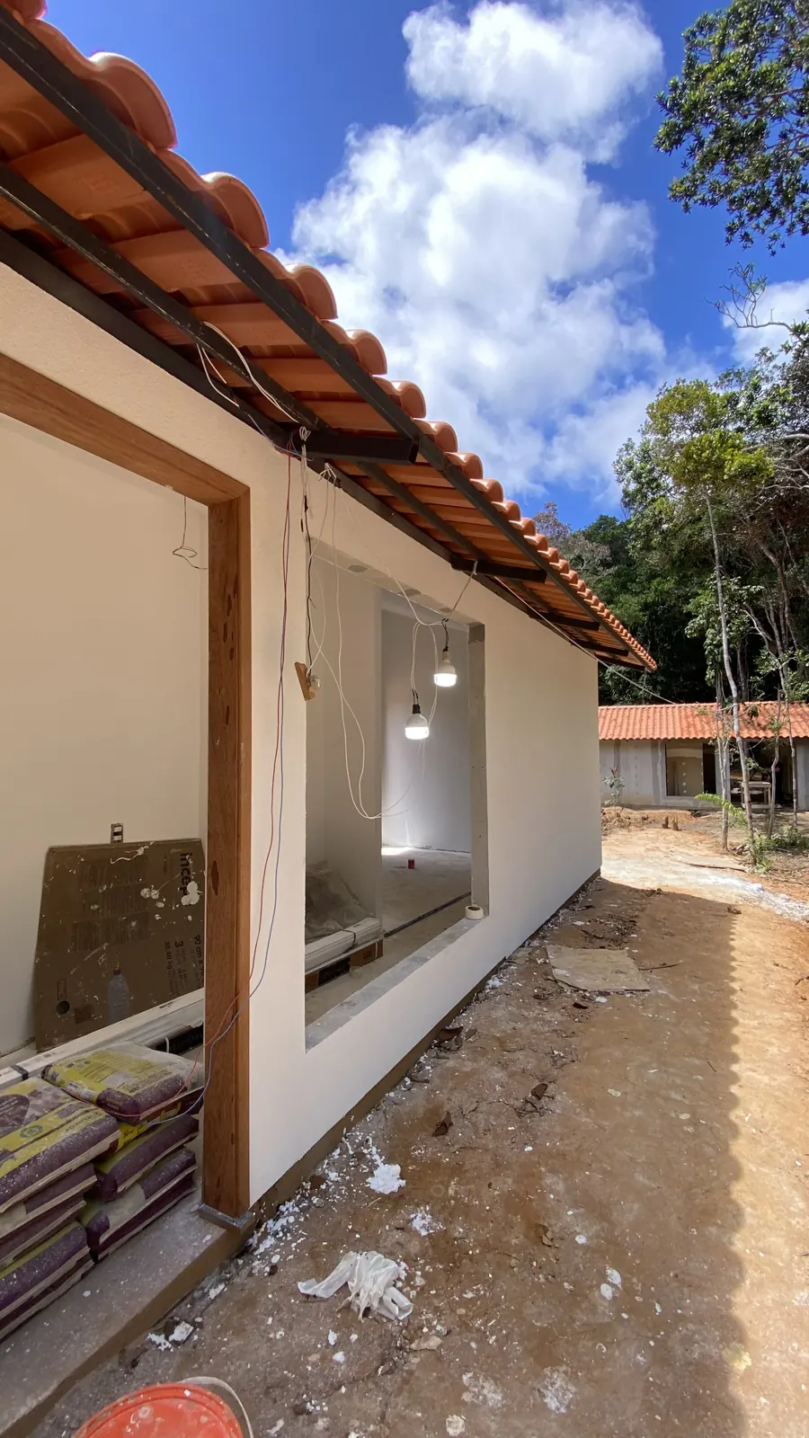 Casita com paredes fechadas e pintadas, telhado concluído e instalação elétrica em andamento